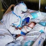 Un’infermiera accarezza un neonato ricoverato con il Covid, la foto fa il giro del web