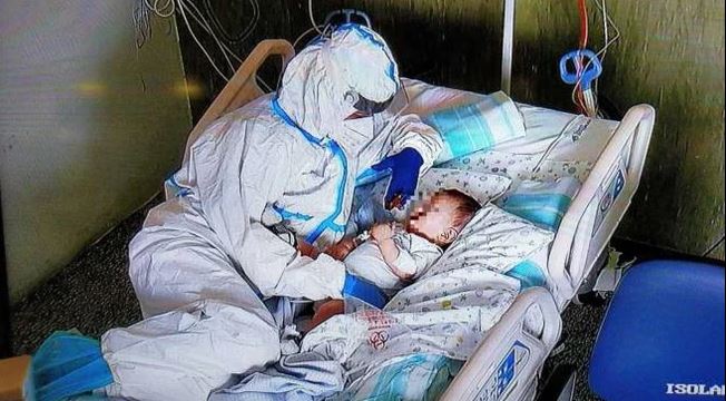 Un’infermiera accarezza un neonato ricoverato con il Covid, la foto fa il giro del web